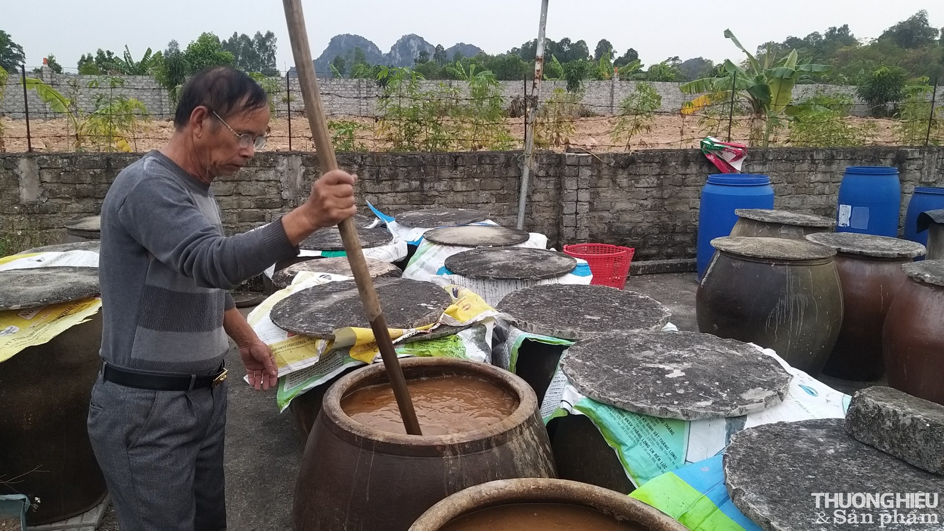 Ông Trần Trọng Phu - Giám đốc Hợp tác xã Chế biến Nước mắm chắt Phu Hiền khuấy nước mắm